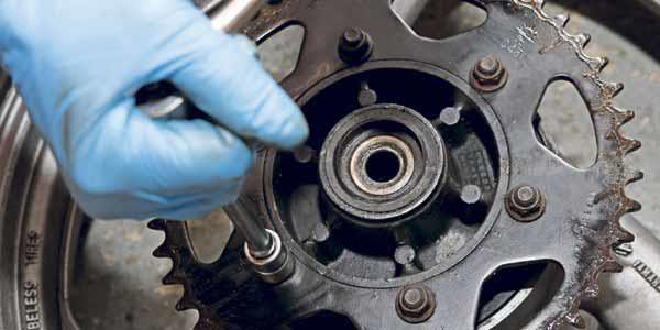 Remove the rear wheel and lay it flat on the floor with the sprocket facing up Remove the rear wheel and lay it flat on the floor with the sprocket facing up