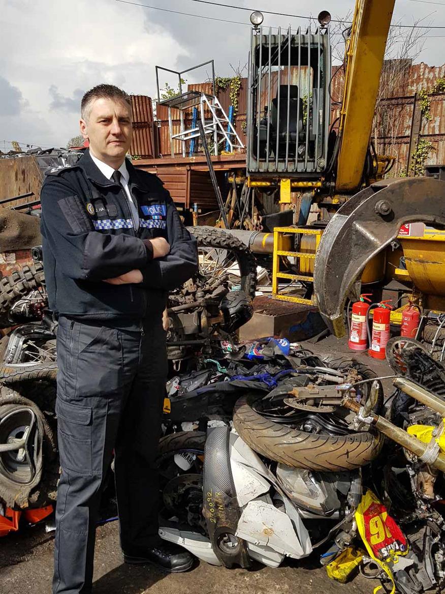 Chief Insp. Hadley with the remains of one of the crushed machines Chief Insp. Hadley with the remains of one of the crushed machines