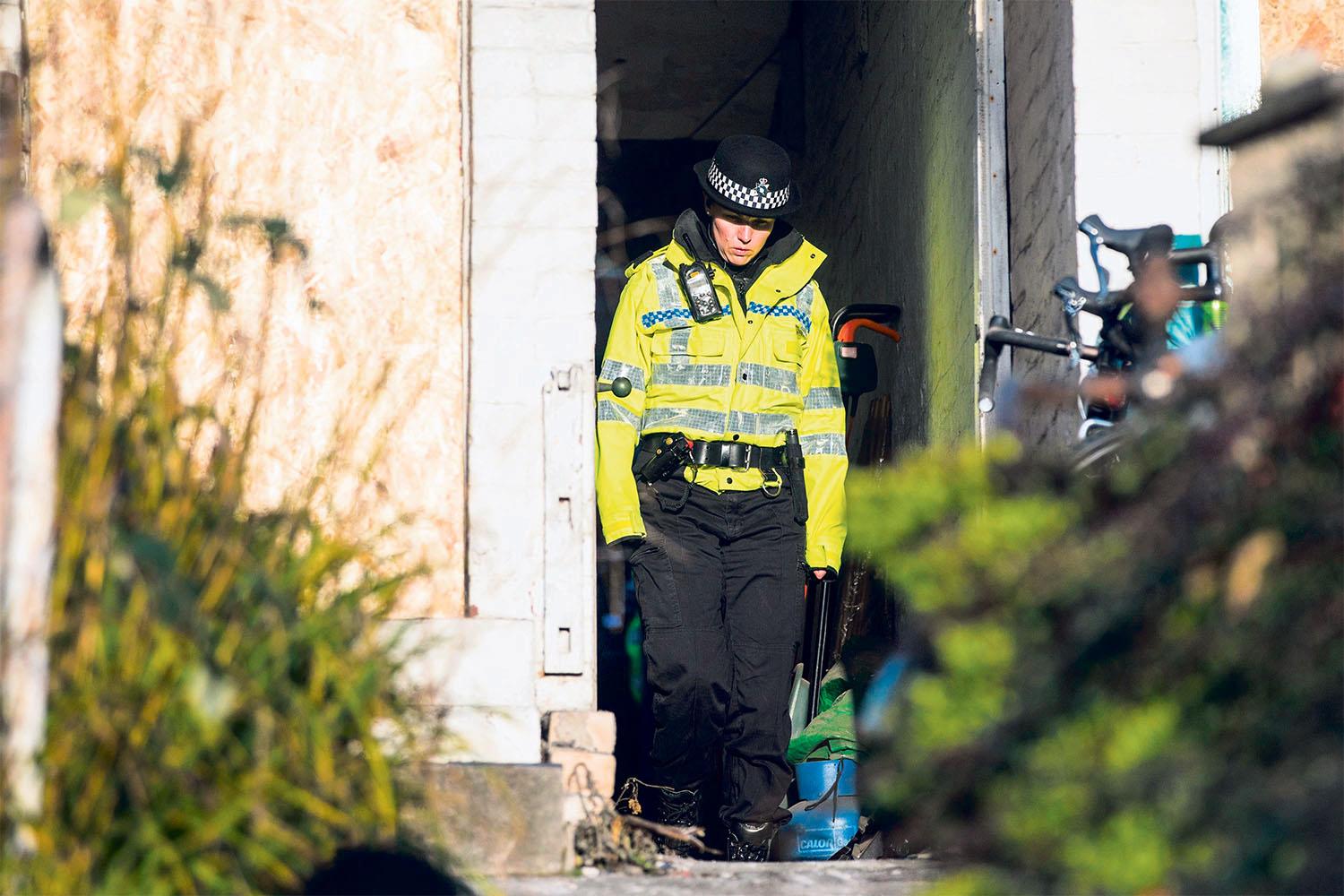 A police officer at one of the raided properties A police officer at one of the raided properties