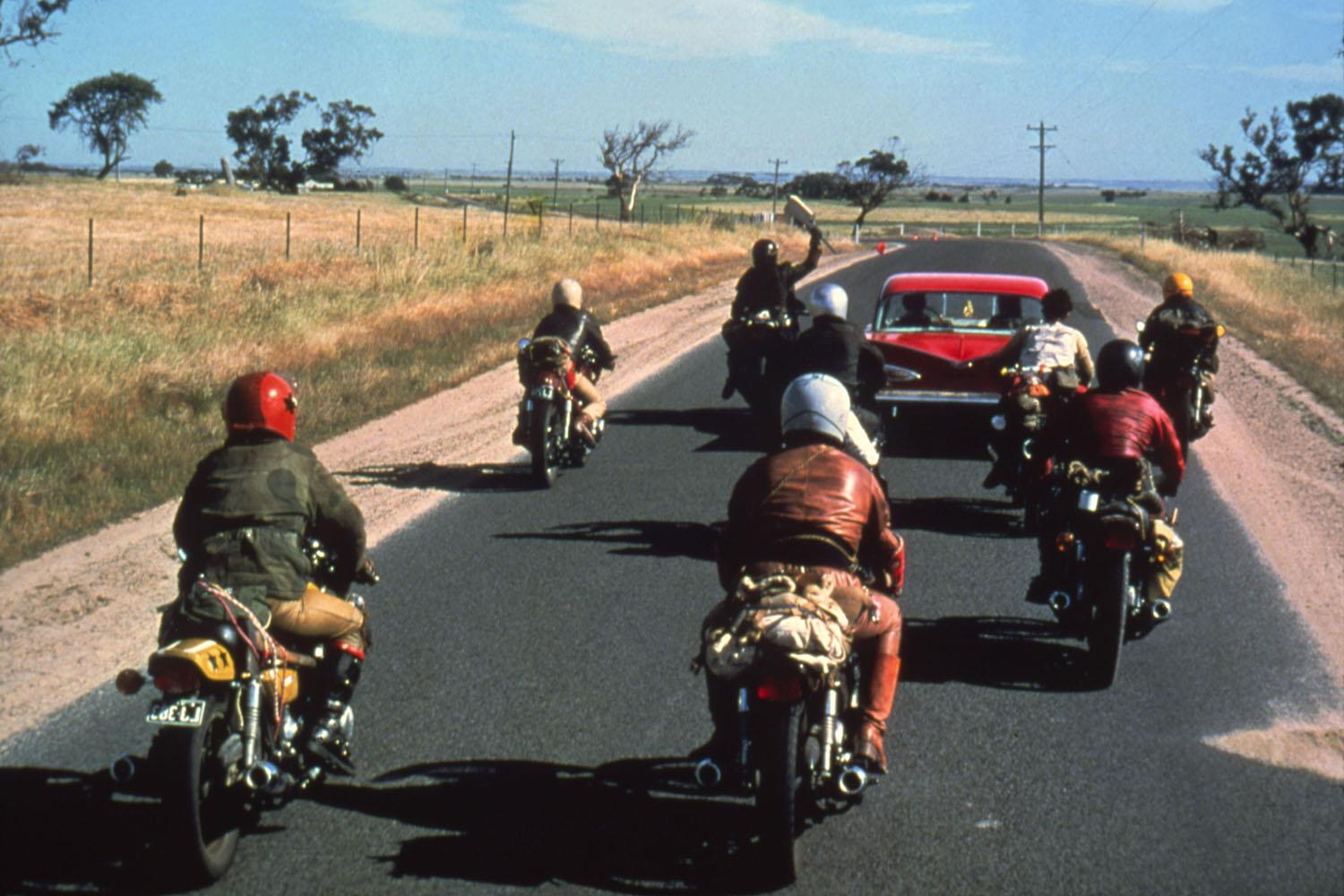Gang members pursue a car in Mad Max Gang members pursue a car in Mad Max