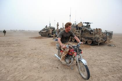 Prince Harry has always been a fan of motorcycles. Pictured here on a CG125 his company found abandoned while on tour in Afghanistan. Photo: John Stillwell/PA Wire 