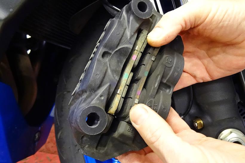 Motorcycle brake pads being checked