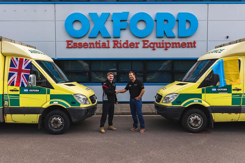 Flynn Watt shakes hands with Henry Rivers Fletcher from Oxford with the two ambulances