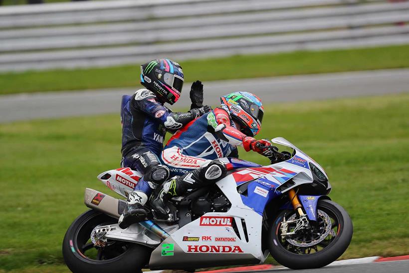 Mackenzie gets a lift back to the paddock with Glenn Irwin after his Race One crash