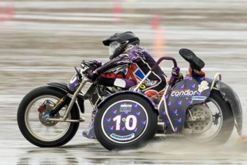 A sidecar co-rider goes feet up as the pair race