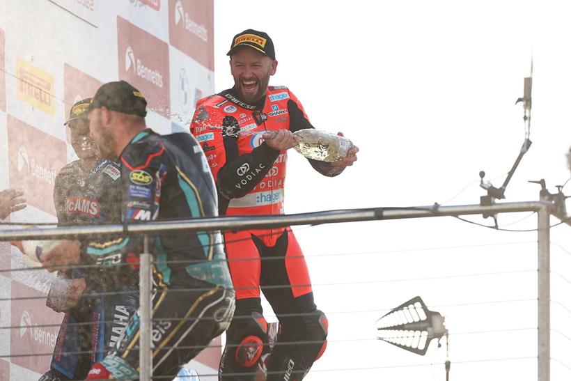 Tom Sykes celebrates victory on the podium at Donington Park