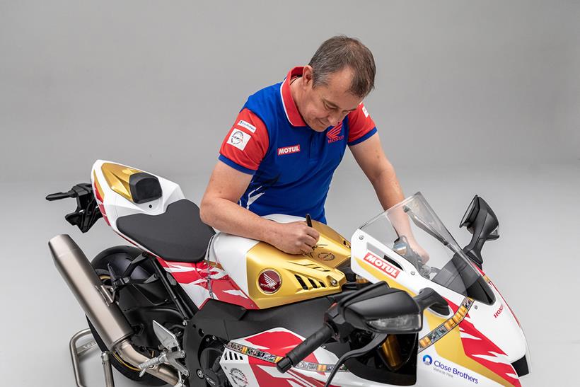 John McGuinness signs the tank of a replica Fireblade