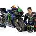 Franco Morbidelli kneels next to his 2023 Monster Energy Yamaha MotoGP bike