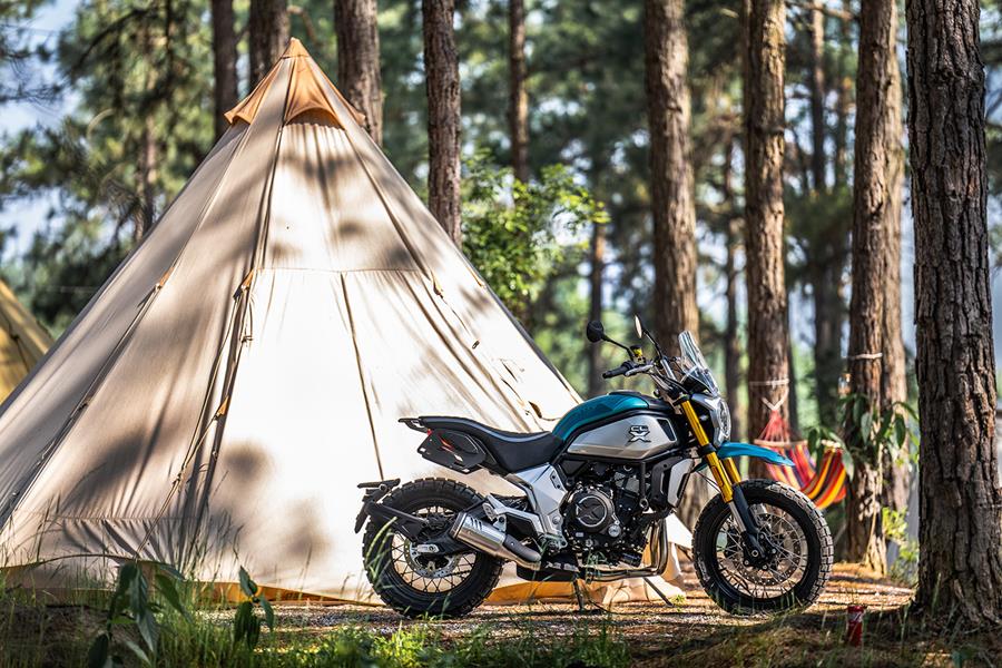 A CFMoto 700 CL-X Adventure parked on a campsite