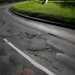 Poor UK road surface with cracks and potholes