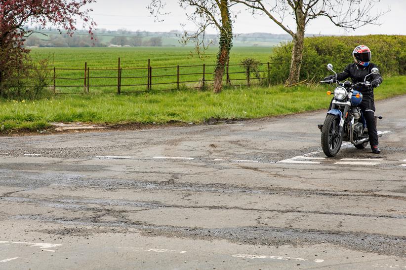 Motorbike on UK road with potholes