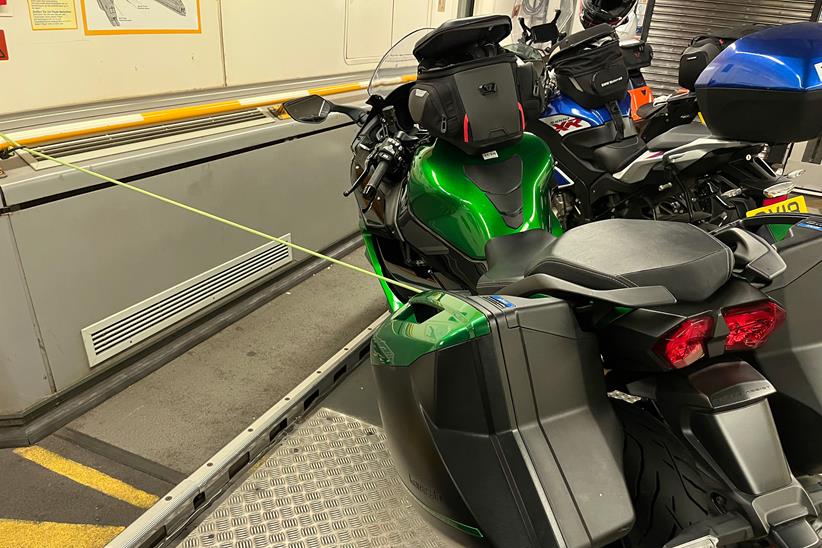 Kawasaki Ninja H2 SX SE long-term test bike hooked to a railing in the Channel Tunnel