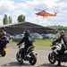 Bikers in procession with a helicopter air ambulance behind