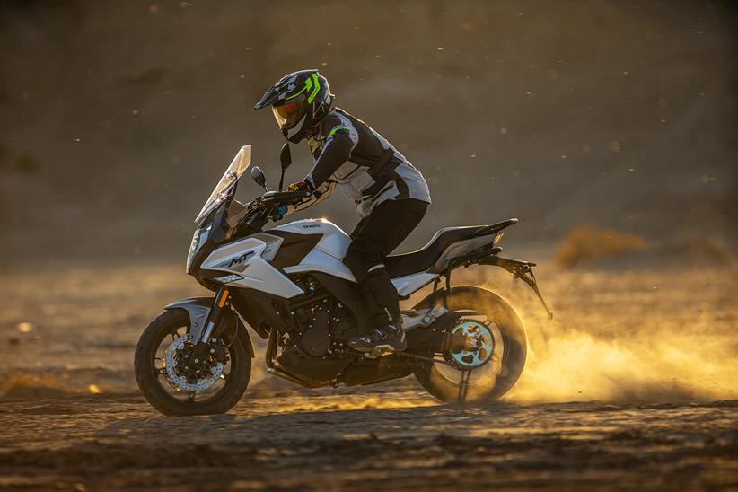 Riding a dusty trail on the CF Moto 700 MT