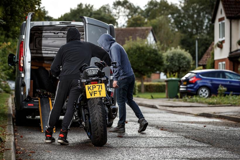 A stolen motorbike is loaded into a van