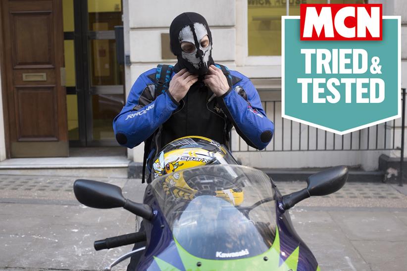 A rider putting on a balaclava, with MCN's Tried & Tested logo