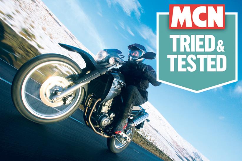 A motorcyclist riding in snowy weather, with MCN's Tried & Tested logo