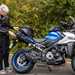 Female rider fitting luggage to Suzuki motorcycle