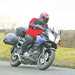 A motorcyclist riding a Suzuki Vstrom with hard luggage