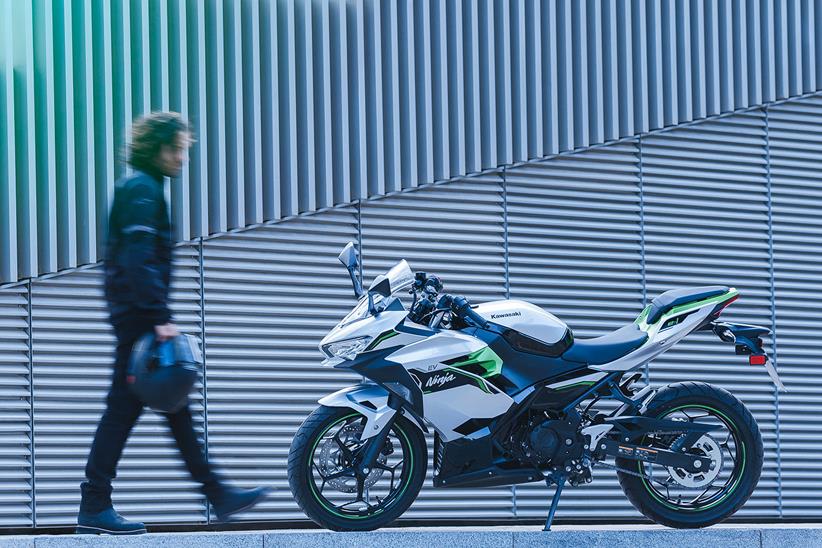 A rider walks to the Kawasaki Ninja e-1