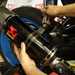 Akrapovic exhaust being fitted to rear hanger of a motorcycle