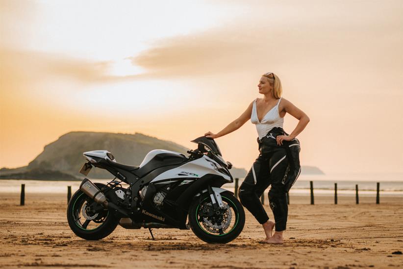 A female motorcyclist poses for the charity calendar on a beach