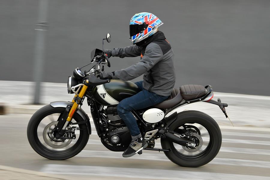 2024 Triumph Scrambler 400 X left side ridden through a town