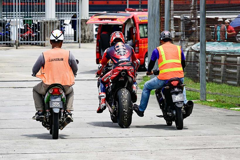 Pedro Acosta is helped back to the paddock after a crash during the Sepang Test