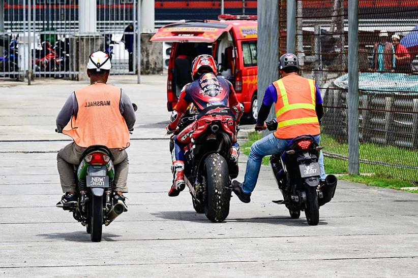 Pedro Acosta is helped back to the paddock after a crash during the Sepang Test