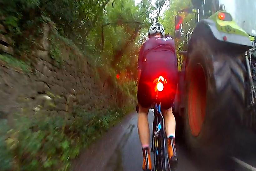 A cyclist narrowly avoids being crushed by a tractor