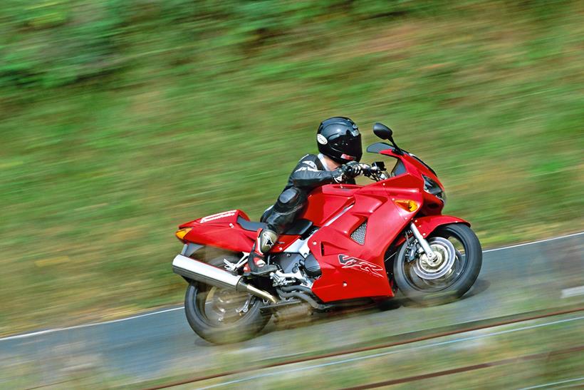 Honda VFR800 sports tourer in red being ridden on the road