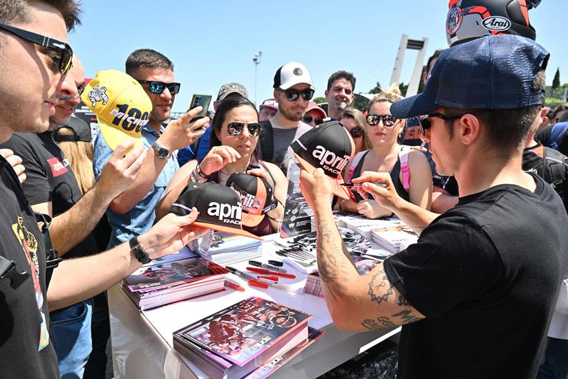 Signing merchandise for fans at Aprilia all stars