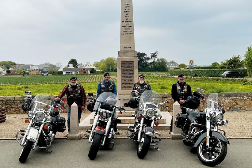 Veteran friends stood with bikes in front of memorial