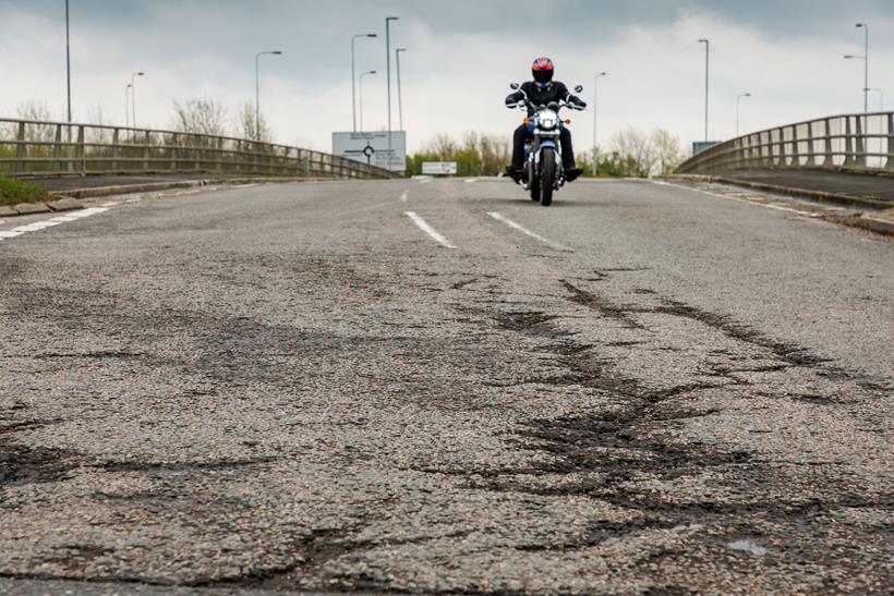 Biker riding along damaged road