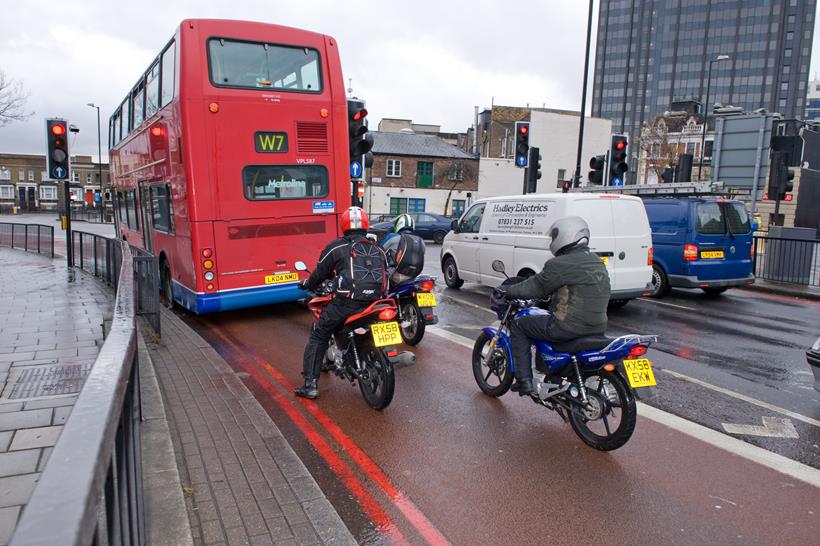 Motorcyclists behind bus in bus lane