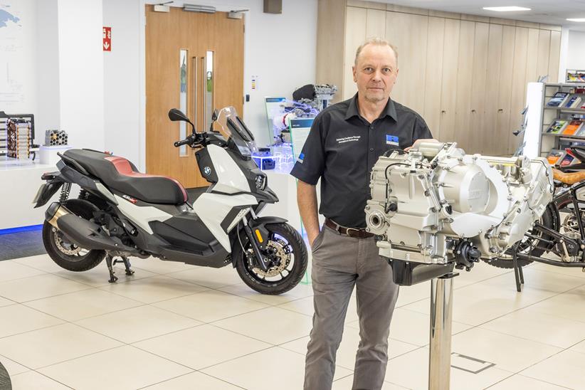 Paul Etheridge standing next to a motorcycle engine