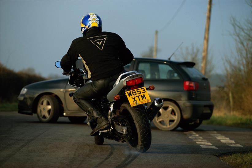 A motorcycle locking up the back wheel to avoid an accident