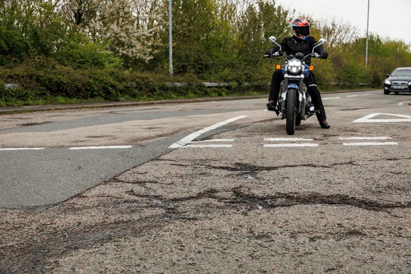 Rider at junction preparing to pull into broken road