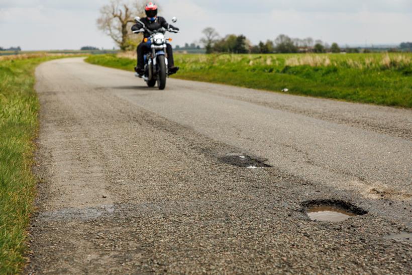 Motorcyclist appraoches potholes