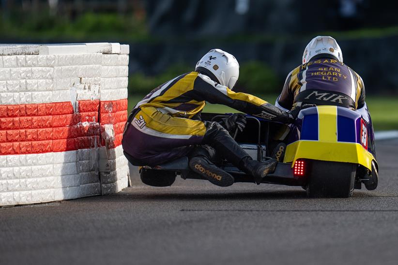 Sidecar passenger skims the wall at Goodwood