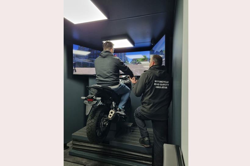 Rider tries out the simulator watched by instructor