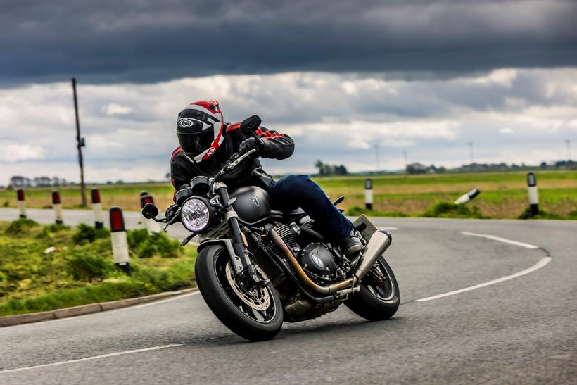 Triumph Twin 1200 riding through a right hand bend with bike and rider leaning into the corner