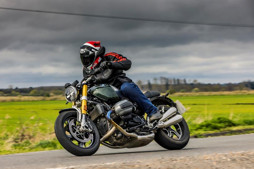 BMW R12 nineT riding past on road with dark sky backdrop