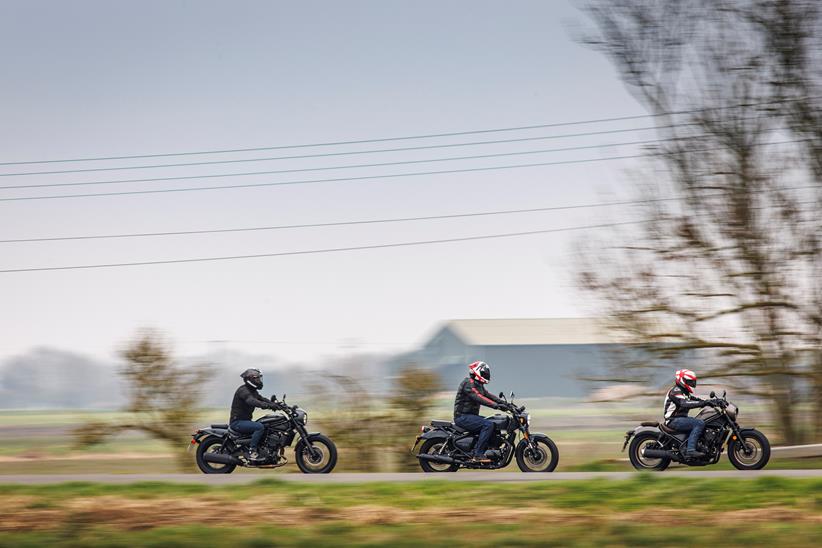 Group shot of mild cruisers test, all three bikes riding past in a line