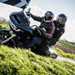2024 Indian Challenger Dark Horse vs Harley-Davidson Road Glide - Harley riding past leaning into a corner with pillion