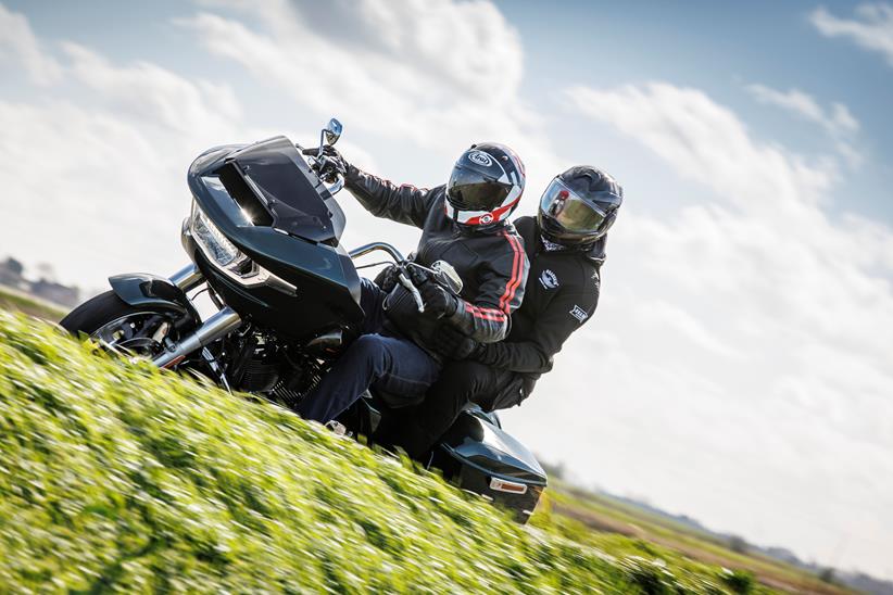 2024 Indian Challenger Dark Horse vs Harley-Davidson Road Glide - Harley riding past with pillion