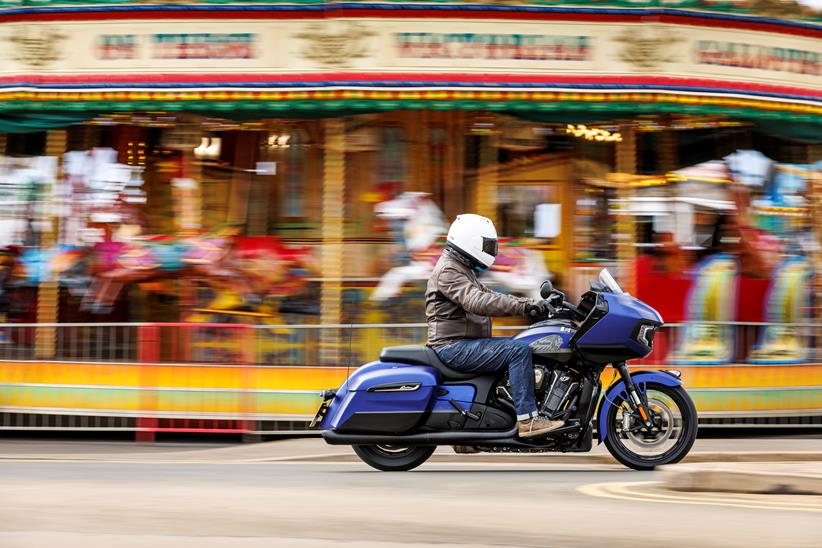 Indian Challenger Dark Horse vs Harley-Davidson Road Glide - side shot of Indian riding past in front of carousel 2