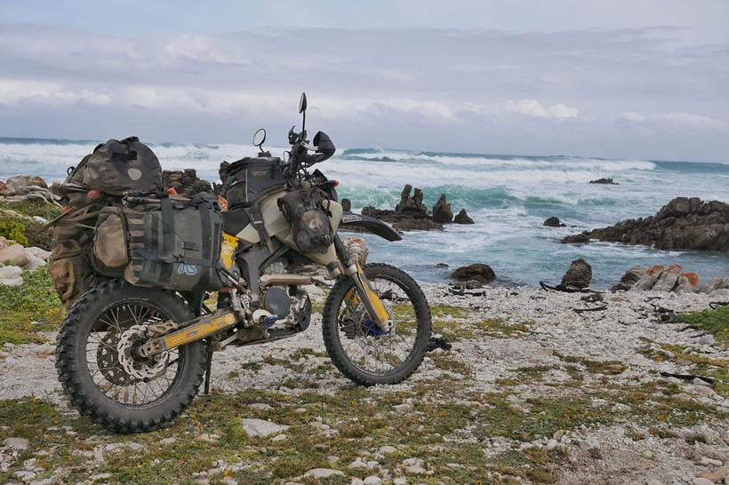 The Adventure Spec Magadan MK3 panniers, pictured next to the ocean in Africa