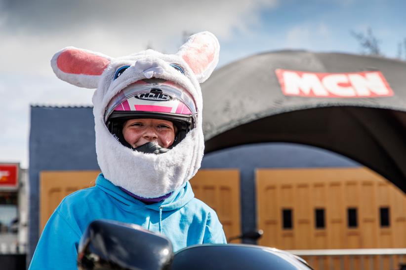 A motorcyclist with a rabbit head helmet cover