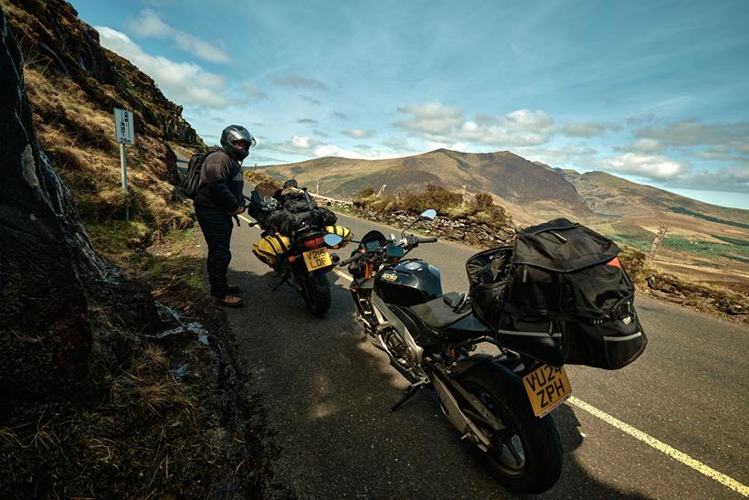 Motorcycles loaded with luggage parked by roadside